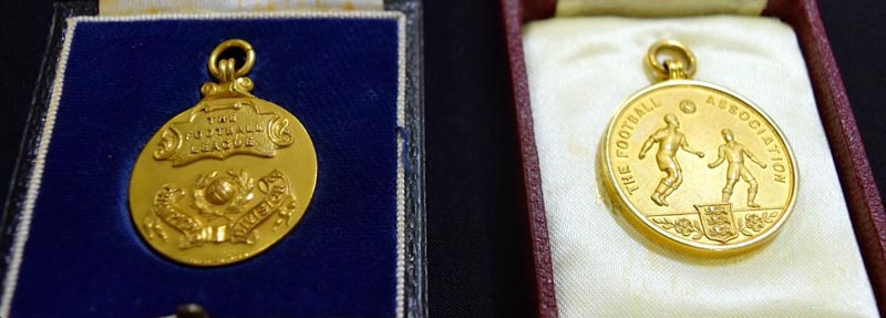 Two gold medals in their presentation boxes