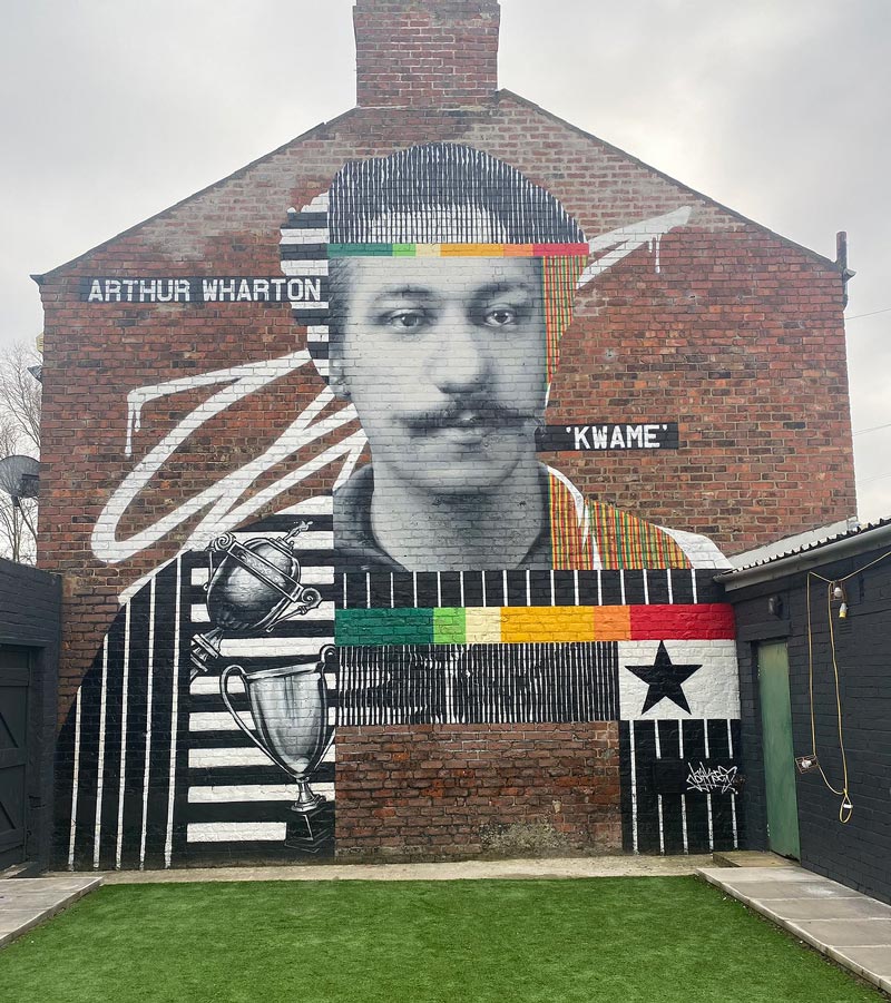Mural on the gable end of a building depicting Wharton