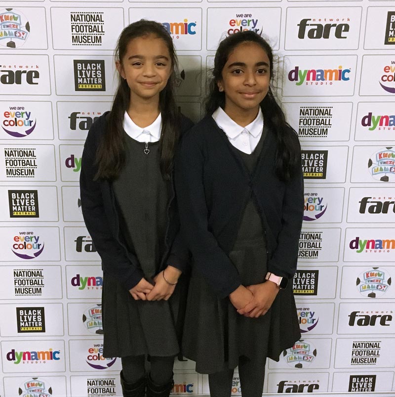 Two Y5 girls photographed against the project bannerstand